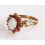 9 carat gold ring with tear drop pierced shoulders under an opal set in garnet surround. ring size L