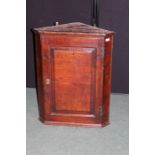 Georgian oak hanging corner cupboard, the panelled door opening to reveal two interior shelves, 58.