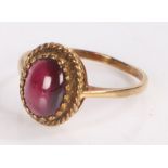 9 carat gold ring the head of rope twist surround and central garnet, ring size O