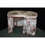 Pine kidney shaped dressing table, with plate glass top above a curtained lower section, 108cm wide