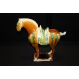 Tang Dynasty style horse, in tan and green glaze, 43cm long