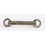 White metal bar brooch the straight bar with circular ends and set with black stones. 4.75cm