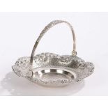 Indonesian white metal basket, with foliate cast swing handle, the pierced dish form base with
