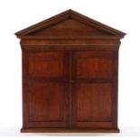 19th Century style walnut hanging cabinet, the triangular pediment above two panelled cupboard doors