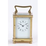 French brass carriage clock, the curved case with swing handle above a rectangular bevelled glass