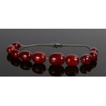 Art Deco cherry amber Bakelite necklace, with a row of graduated beads and chain to the back, the