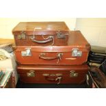 Three brown leather suitcases, the largest 60cm wide (3)