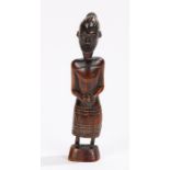 Ethnographical carved figure, of a figure with the hands folded to the lap over the dress, the