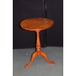 Walnut wine table, the circular top on a vase shaped stem, raised on tripod legs, 51cm diameter