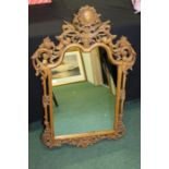 Carved pine wall mirror, with scroll and leaf carved pierced arched frame, 58cm x 86cm