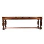 17th Century style oak refectory table, the plank top raised on acanthus leaf and scroll carved legs