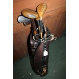 Hickory shafted golf clubs, to include three irons, two putters and two woods, housed in a leather