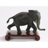 Japanese Meiji period bronze elephant, on a hardwood stand, the elephant 21 cm wide, 12.5cm high