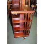 Edwardian mahogany revolving bookcase, on an X from base and later castors, 50.5cm square