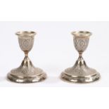Pair of Iranian white metal candlesticks, with foliate and scroll decoration, 10cm high, 10oz