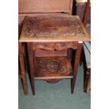 Oak occasional table, with carved top and frieze drawer, on carved square tapering legs united by