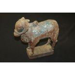 Wooden carving depicting a sacred cow, with remnants of blue painted decoration, 27cm high