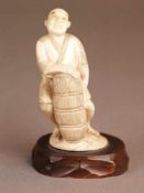 Okimono eines Fischers mit Korb - Japan,wohl Meiji-/Taisho-Periode, Elfenbein, geschnitzt, Gewand