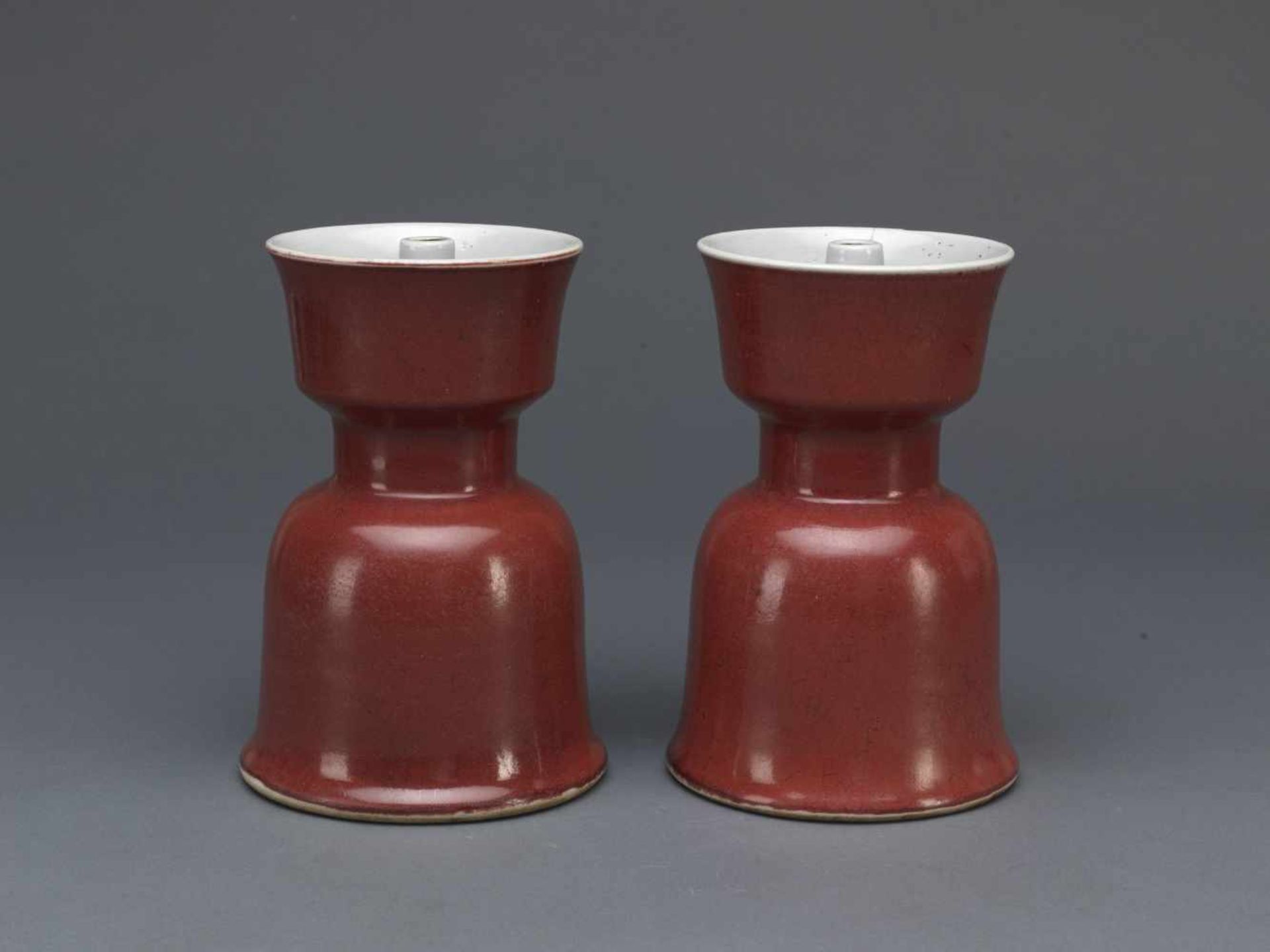 A PAIR OF RED-GLAZED CANDLESTICKS,QING DYNASTY.Paar „Langyao“-Kerzenhalter – China, Qing-Dynastie,