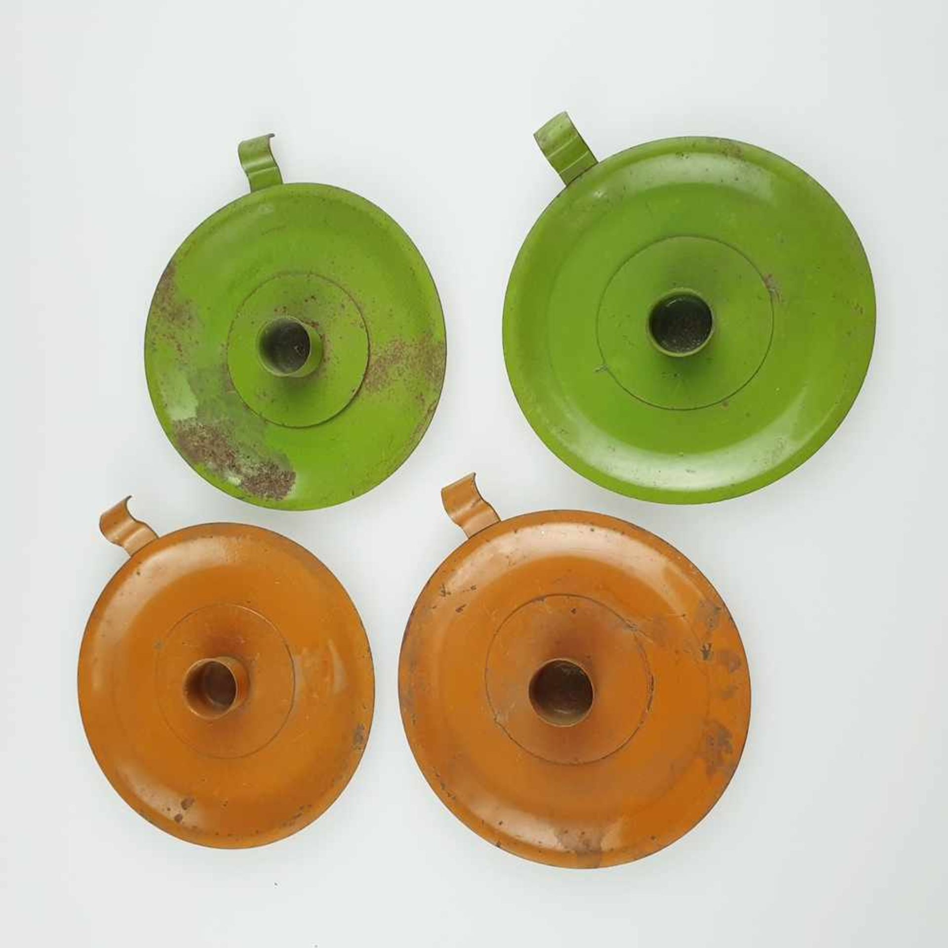 Vier Kerzenhalter - Metall, 2 grün / 2 orange gefasst, runde Form mit zylindrischer Kerzentülle