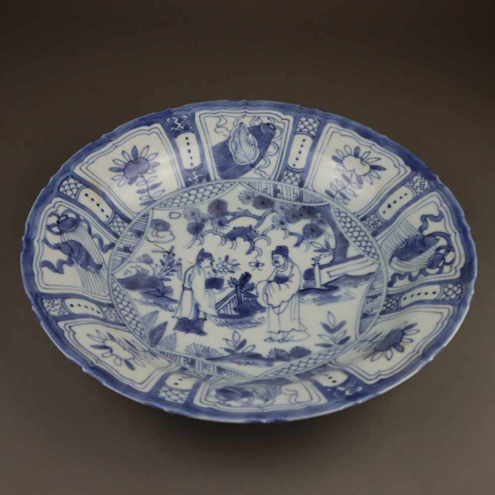 Blue and white plate - China, Qing dynasty, slightly waved round shape, porcelain lavishly painted