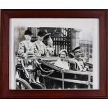 Queen Elizabeth II and the Shah of Iran riding in a coach through the gates of Buckingham Palace