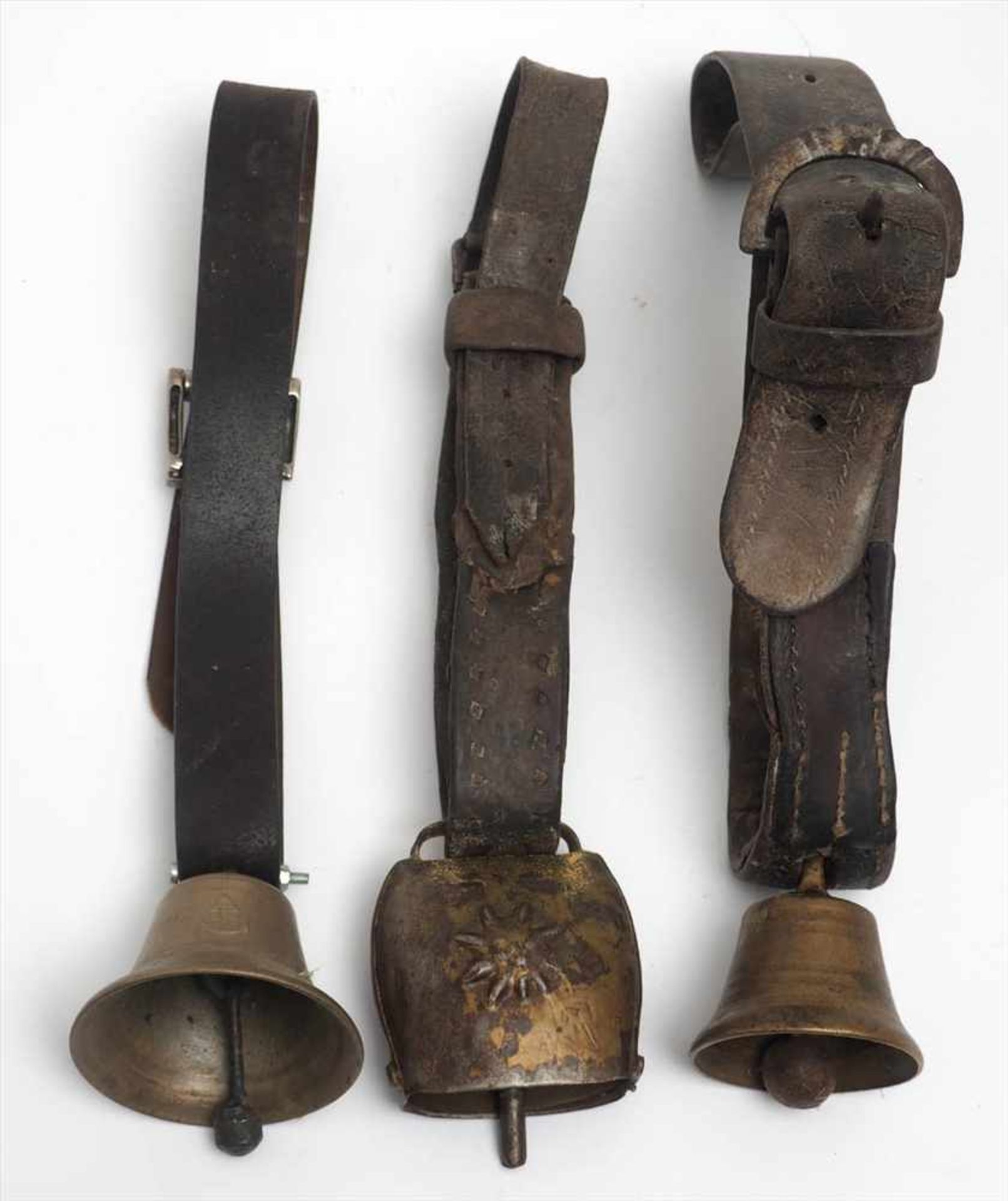 Drei KuhglockenH.8, 11 bzw. 7cm. Eine mit metallbeschlagenem Lederband.