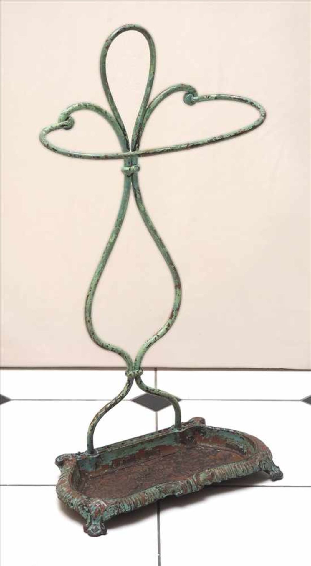 Schirmständer, um 1900Bewegte, reliefierte Bodenplatte, geschwungenes Gestell. Eisen, lackiert. H.