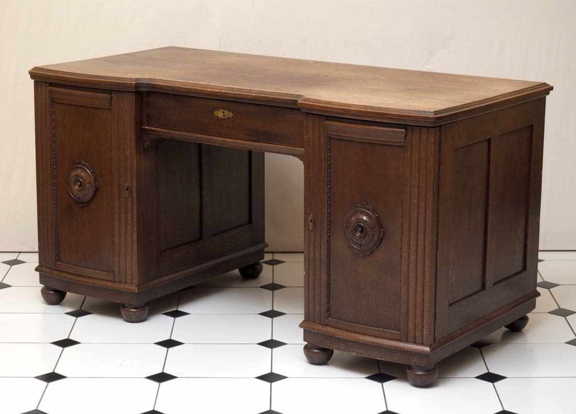 Schreibtisch, um 1900Auf vier Kugelfüßen Unterbau mit zwei Türen und großer, zurückgesetzter