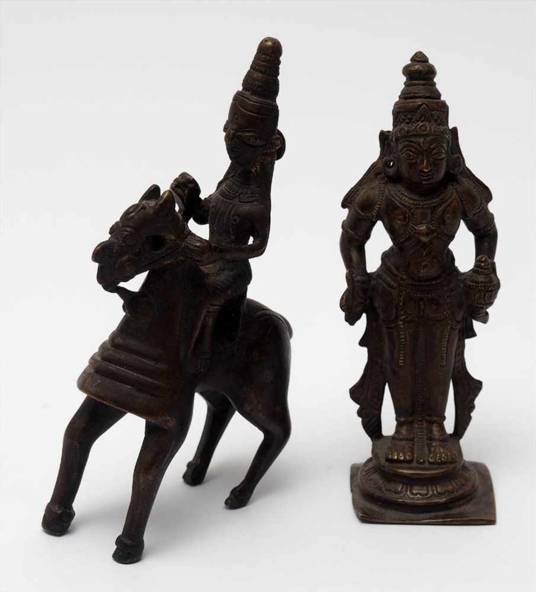 Zwei Bronzefiguren, IndienGöttergestalt, stehend bzw. reitend. Braune Patina. H.13 bzw. 12cm.