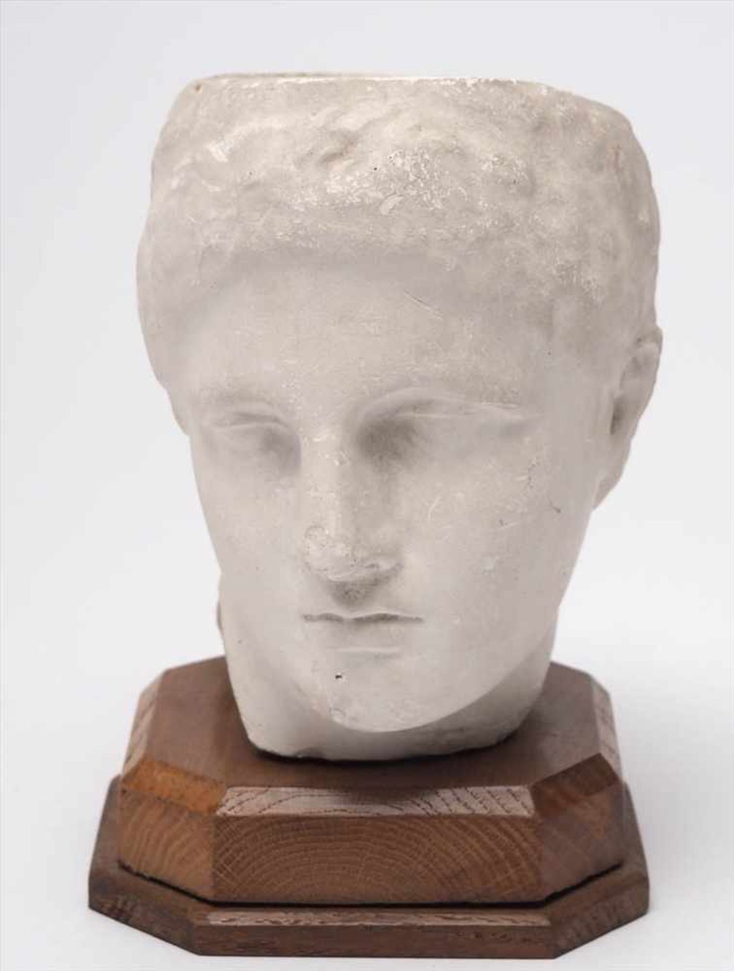 MuseumsreplikKopf eines griechischen Jünglings, auf Holzsockel montiert. Stuck. H.18cm inkl.