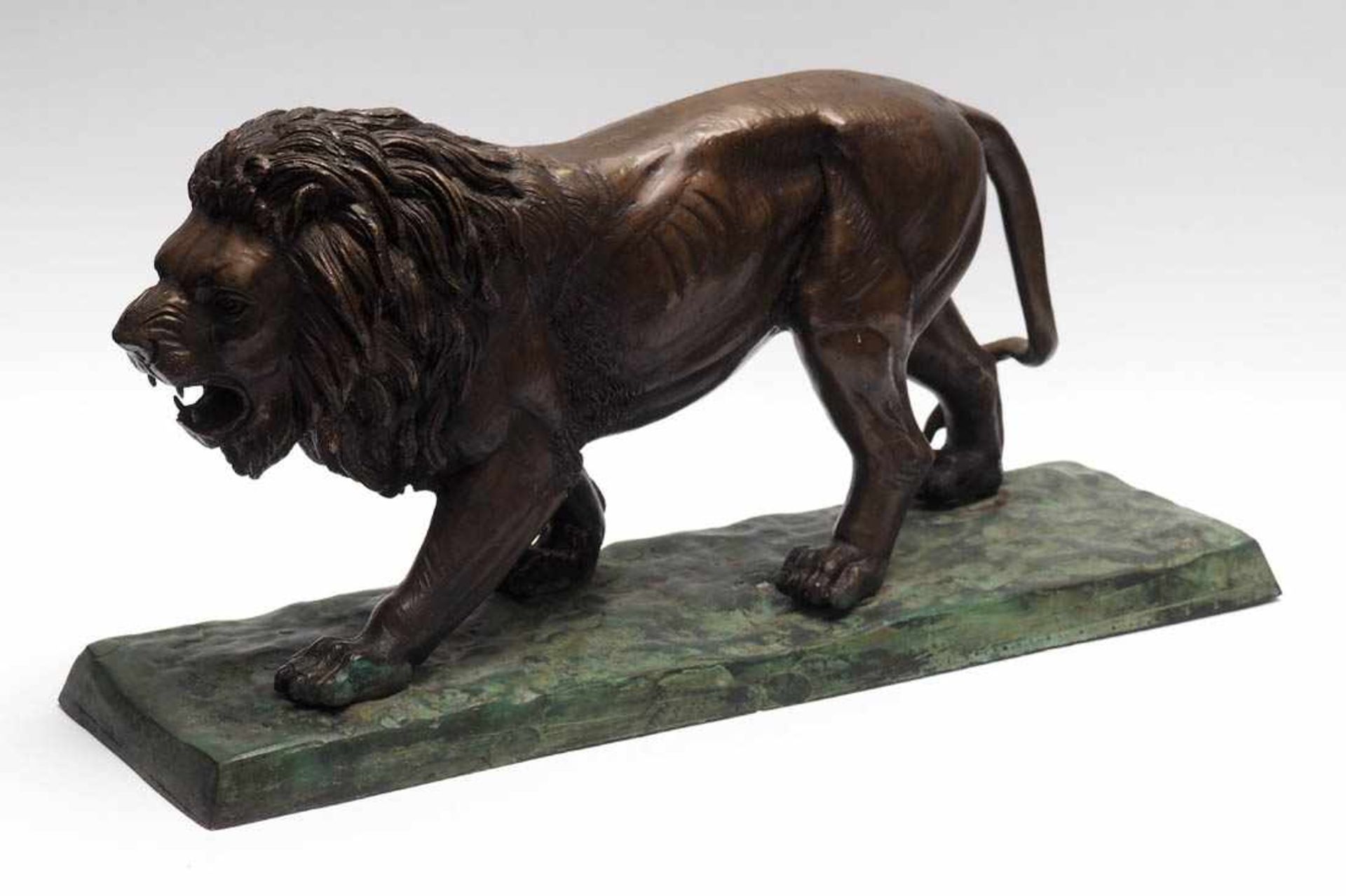 TierfigurineAuf reliefiertem Sockel schreitender Löwe in naturalistischer Ausformung. Bronze, braune