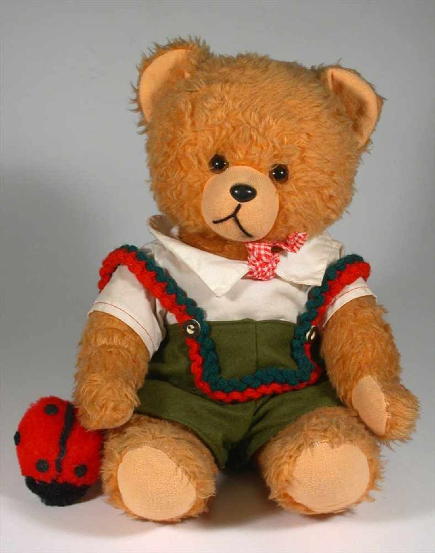 Teddy, HermannWeichkörper aus hellbraunem Plüsch, Glasaugen, Kunststoffschnauze. Originalkleidung.