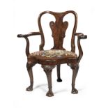 A George I carved and figured walnut corner or 'writing' armchair in the manner of William Hallett