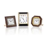 Three gilt brass and lacquer alarm desk clocks by Cartier,