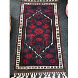 A Small Arabic hand woven rug. Measures 114x60 inc tassels.