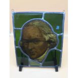 An antique stain glass window panel centred with a hand painted portrait of a gentleman. Measures