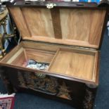 A large oriental camphor chest carved with pagoda scenes to the exterior and a sliding drawer to the