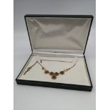 A 9ct gold flower and leaf design necklace, set with 5 garnet stones