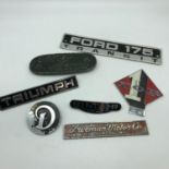 A Lot of vintage car badges which includes Fellowship of Riders motorcycle badge, Triumph badge,