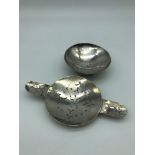 A solid silver hammered arts and crafts strainer and dish.