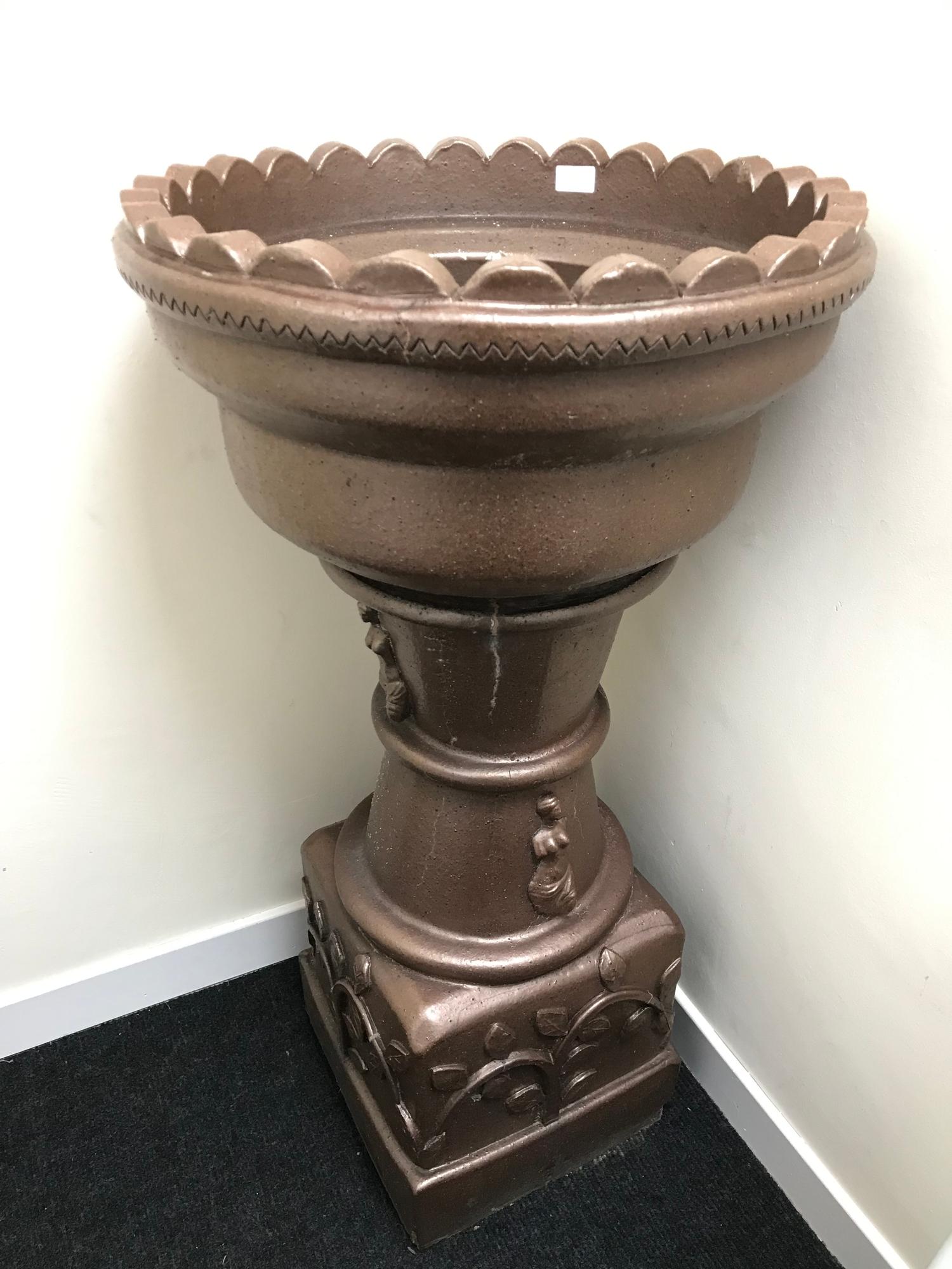 A Large heavy brown glazed stone pedestal plant stand.110CM. 57CM IN DIAMETER