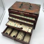 An early 1900's Mahjong set, made with bone and bamboo, fitted within a small hard wood chest