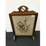 A small arts & crafts fire screen fitted with a floral tapestry