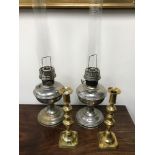 Two paraffin lamps together with Victorian brass push candle sticks.