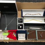 A box filled with boxed costume jewellery.