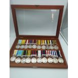 A collection of various military medals together with ribbons, within a presentation case