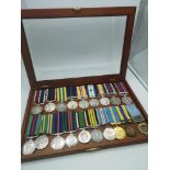 A collection of various military medals together with ribbons, within a presentation case