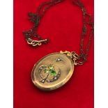 A Victorian Gold locket set with seed pearls and 3 green stones. Comes with a vintage necklace.