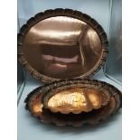 A set of three arts & crafts copper trays with a scalloped edge detail, stamp to the base